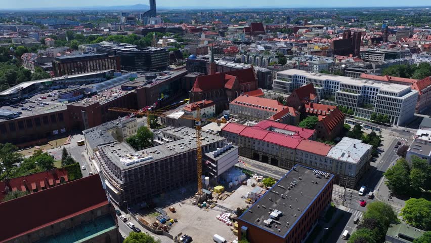 Ancient Horizon to Modern Height: Cinematic Panorama from Mount Ślęża to Sky Tower. A striking aerial panorama that captures the contrast between the natural and modern landmarks of Lower Silesia. The footage pans from the distant, blue silhouette of Mount Ślęża on the horizon to the sleek, towering form of the Sky Tower (212m), Wrocław