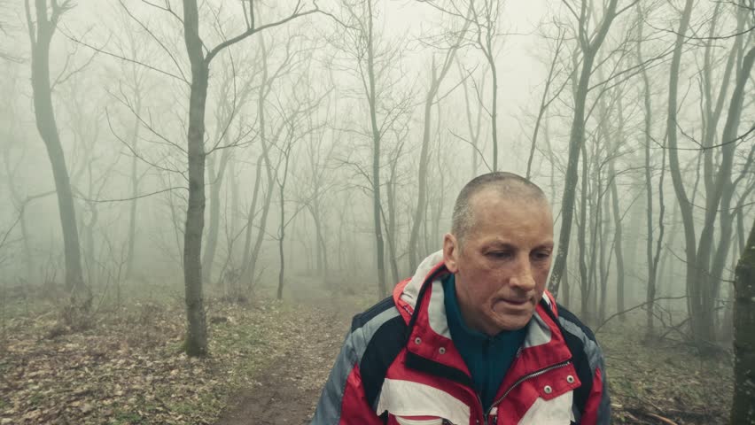 Stress relief walk of 50s male in foggy winter landscape
