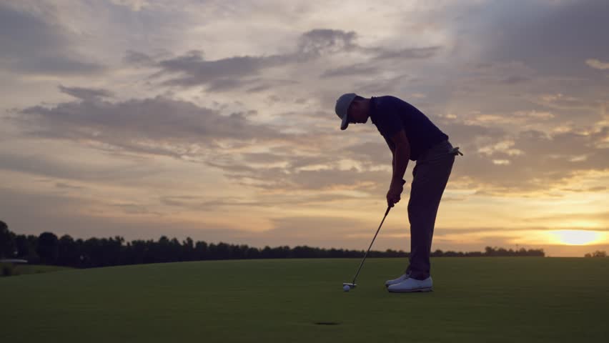 Professional young male golfer swings his club on scenic golf course. Attractive sportsman enjoy outdoor recreation with light exercise and sport lifestyle while playing golf at course grounds.
