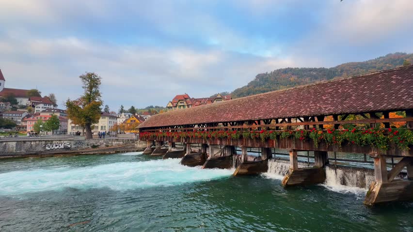 River surf wave Flusswelle Aare River sunny blue sky morning Thun Thunersee Switzerland Schweiz Europe Autumn Fall wooden bridge fast moving high flow urban surf scene water sport Thun Castle pan left