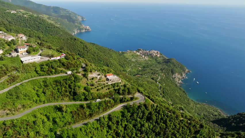Drone following a RV driving on a mountain road, summer in Cinque Terre, Italy