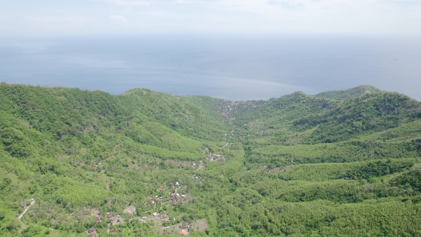 Lush, Tropical Landscape Of Mountains And The Calm Blue Sea In Summer In Indonesia. - aerial shot