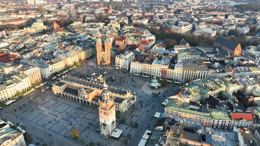 Low altitude aerial flyover of Rynek Główny Square with St. Mary’s Basilica and historic Old Town architecture, Kraków, Poland