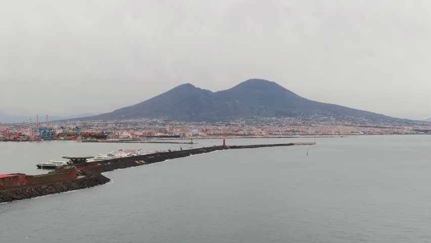 Panoramic view of Naples harbor, Mediterranean sea, and the iconic Vesuvius volcano in Italy