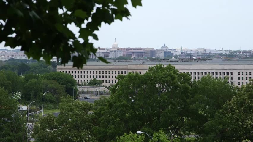 Pentagon complex in Arlington, Virginia near Washington, D.C., viewed across trees with the D.C. skyline in the background on an overcast day