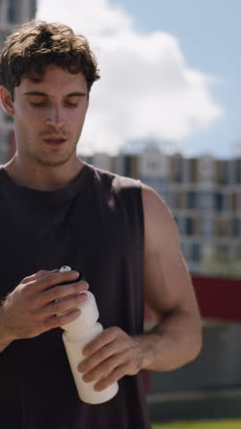Tired strong sport Caucasian man drinking water holding bottle drink protein aqua in city athlete male guy refresh enjoy relaxing after sporty fit workout healthy lifestyle wellness sportsman thirsty