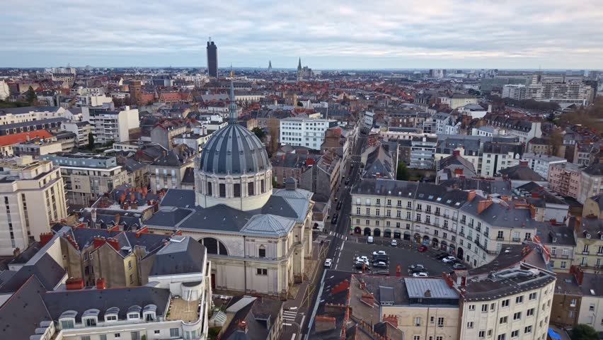 Drone fly over domed Notre-Dame de Bon-Port roman catholic basilica at dense historic city center, Nantes, Loire-Atlantique, France