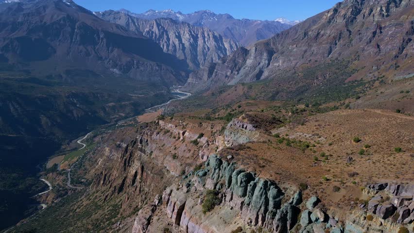 Drone orbit reveal of eroded cliffs with mountain range. Mirador de los Condores, Santiago, Chile