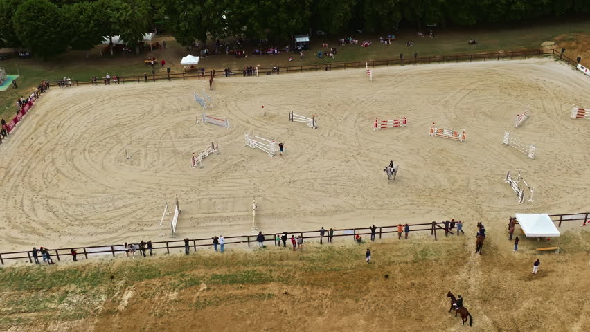 Aerial view of equestrian competition outdoors jumping hurdle