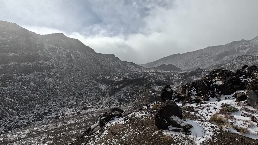 Pristine winter landscape of Tongariro National Park, New Zealand, featuring snow-capped volcanic peaks and rugged alpine terrain