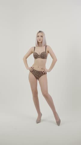 Full length of woman in black underwear and boots posing