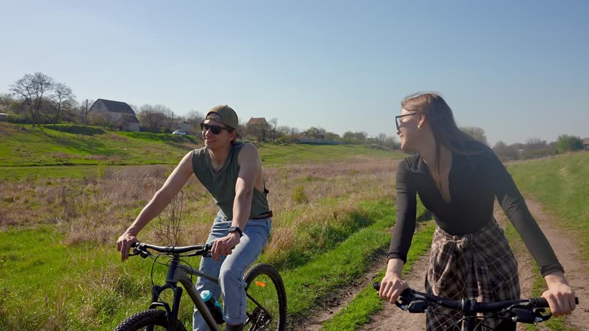 A couple rides bicycles on a scenic outdoor trail, surrounded by nature, capturing the essence of adventure and relaxation in the countryside.