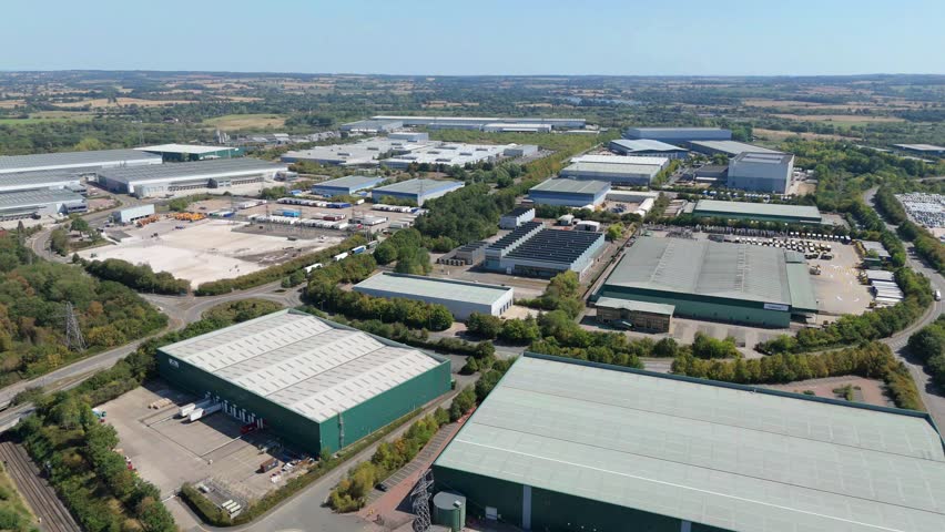 Aerial drone view of a massive logistics distribution centre and industrial business hub for manufacturing on the outskirts of Birmingham England UK