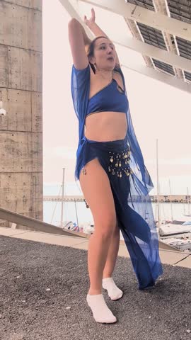 Sensual belly dancer performing outdoors near a marina