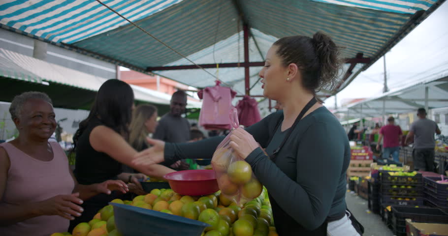 Woman vendor greeting senior shopper after purchase at neighborhood street market conveying friendliness gratitude and everyday human connection through food trade