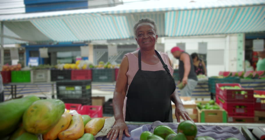 African American senior vendor standing at neighborhood produce stand conveying dignity experience daily routine and deep connection to community street market life