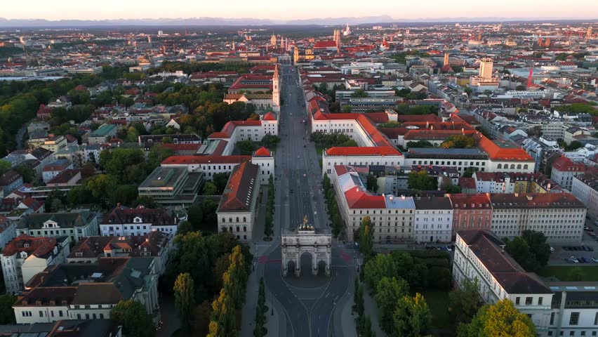 Aerial summer view of Munich at sunrise, featuring the iconic Siegestor triumphal arch, Bavaria statue with lions, Ludwigstrasse, and Leopoldstrasse, perfect for travel and architectural video content