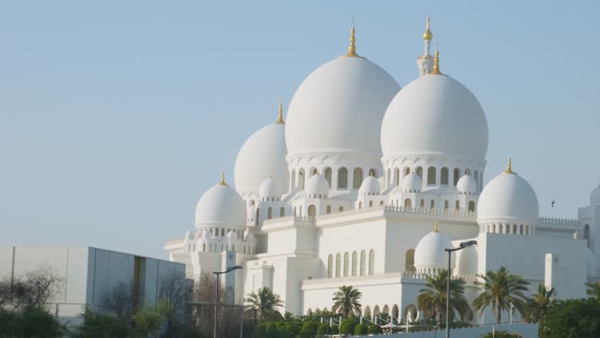Sheikh Zayed Grand Mosque with multiple domes and minarets under clear blue sky in Abu Dhabi, United Arab Emirates. Islamic architectural heritage. Travel and tourism in UAE