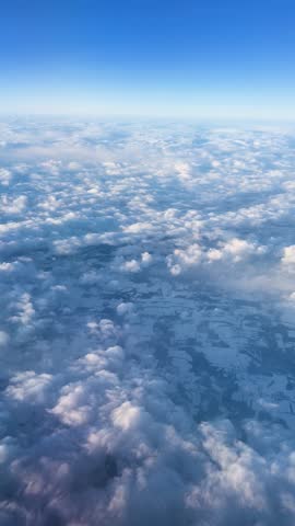 Scenic aerial view of clouds over snowy landscape, captured at sunrise