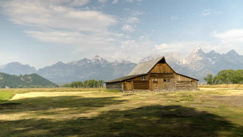 A scenic view of the historic T.A. Moulton Barn with the Grand Teton mountains in the background.