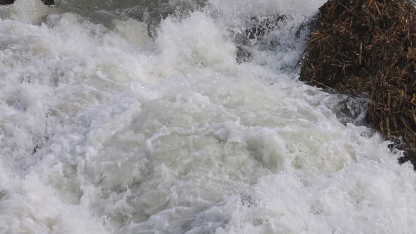 Close up view of fast flowing white water rapids in Cornwall, England, showing turbulent freshwater movement, splashing foam, natural energy, and raw river power in outdoor setting