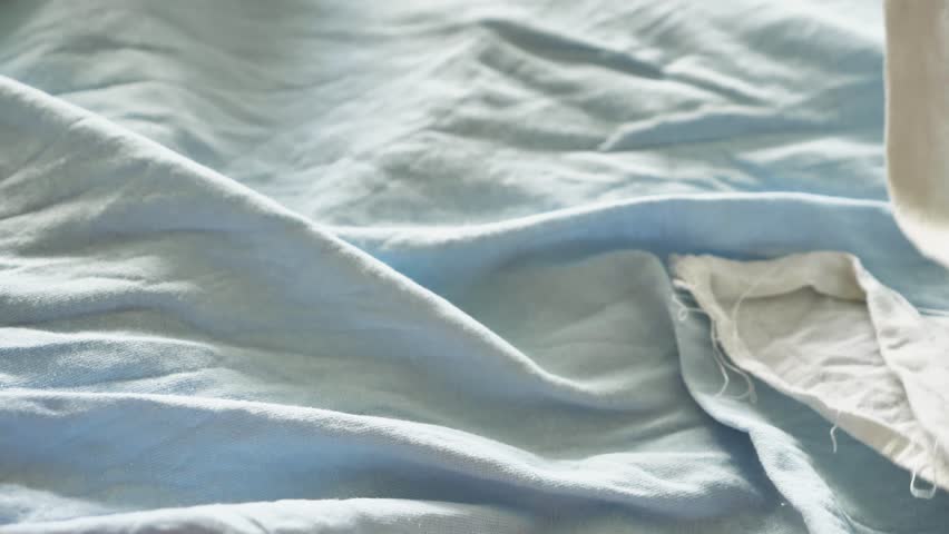 Tender close-up of a newborn's feet on a soft blue blanket. Natural light highlights the delicate skin and tiny toes, conveying innocence, fragility, and the wonder of new life