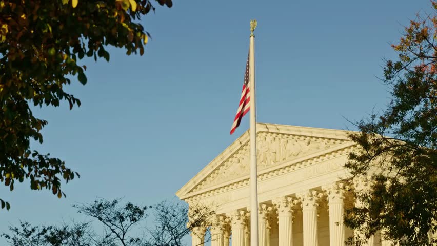 Facade of the United States Supreme Court building against a clear blue sky, highlighting iconic architecture, government, and historic landmarks.