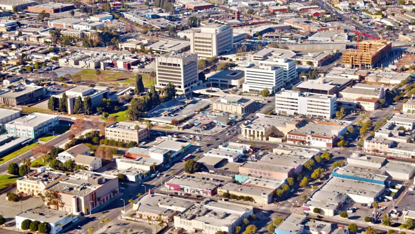 Aerial view of downtown San Jose, California on a sunny day with clear skies, showcasing modern buildings, streets, and city life.