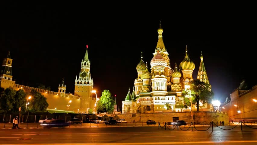 Saint Basil’s Cathedral and the Kremlin at night in Moscow, Russia, brightly illuminated, showcasing iconic architecture, historic landmarks, and city lights.