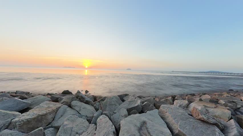 Soft sunrise over rocky shoreline by the sea in Malaysia