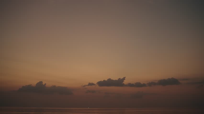 Serene sunset over ocean with calm clouds in a peaceful evening sky