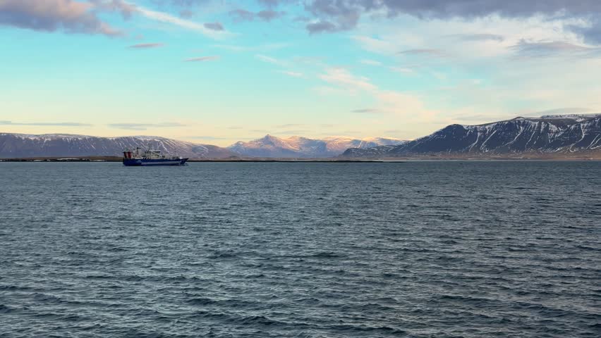 Boat In a Arctic Coastline Landscape Lined With Mountains In Iceland At Sunset, Panning Shot