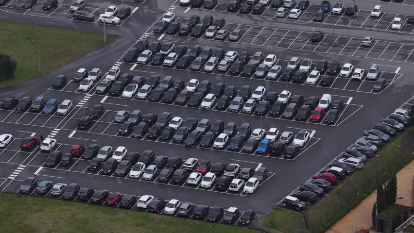 Parking lot with a lot of cars near factories and hospital