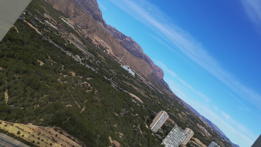 Aerial View of Intempo Building in Benidorm Spain Featuring Unique Architecture Golden and Mountain Backdrop Under a Blue Sky a Tourist Destination