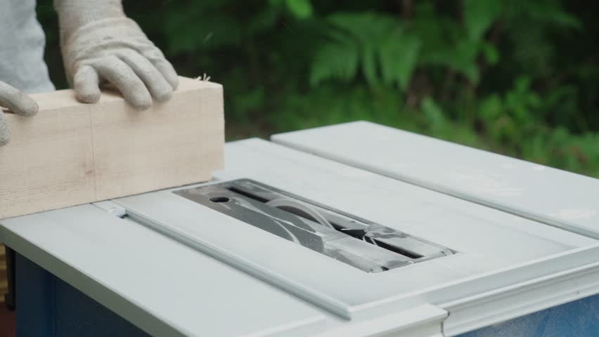 Carpenter Using Table Saw Mill on a Piece of Timber - Close Up Hands