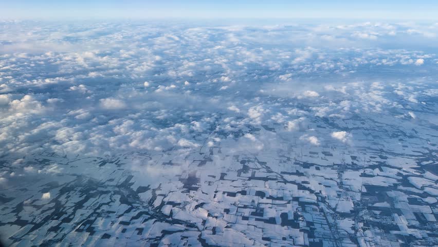 Ontario skyline from a plane, cloud layers over snowy fields, serene view
