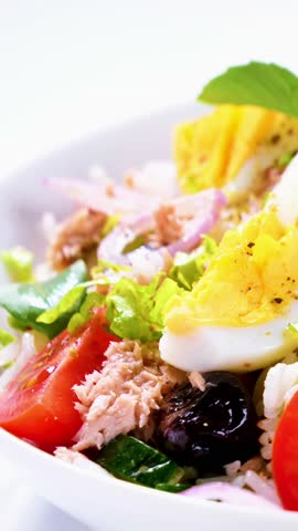 mixed salad with egg, tuna, rice, tomato and basil	
