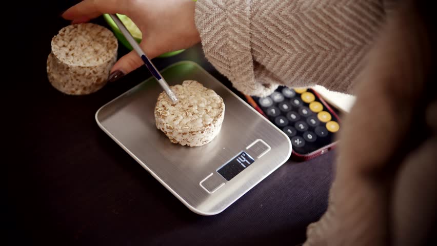 Dieting Person Measuring Rice Cakes On Silver Kitchen Scales, Healthy Lifestyle Nutrition With Dieting Person Counting Calories Of Rice Cakes, Balanced Weight Loss Routine, Dieting Person Checking Rice Cakes Mass Using Electronic Kitchen Scales, Precise Food Portion Control On Digital Kitchen Scales