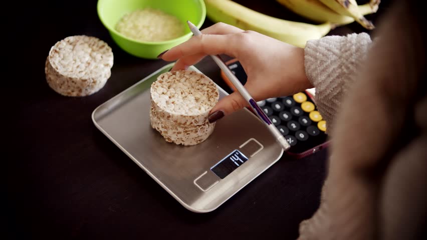 Dieting Person Measuring Rice Cakes On Silver Kitchen Scales, Healthy Lifestyle Nutrition With Dieting Person Counting Calories Of Rice Cakes, Balanced Weight Loss Routine, Dieting Person Checking Rice Cakes Mass Using Electronic Kitchen Scales, Precise Food Portion Control On Digital Kitchen Scales