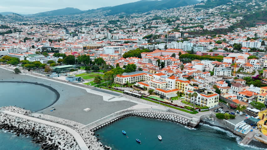 Aerial view of Funchal coastal city with urban waterfront, residential districts, and Atlantic shoreline on Madeira, Portugal