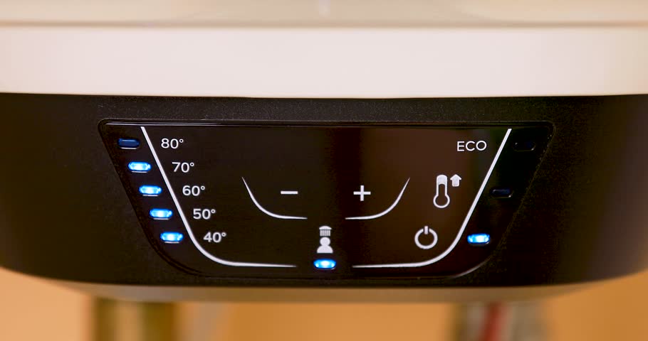 Close-up of a water heater heating water as a hand adjusts the temperature control. Energy saving, efficiency, utility management, and home technology concept. 4K video.