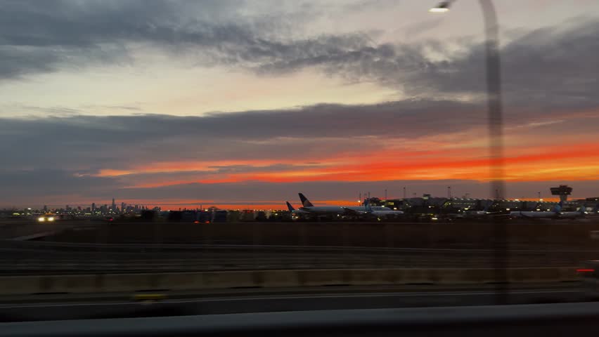 Vibrant sunset over Newark_EWR Airport with cityscape in background