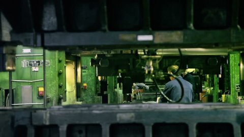 TOGLIATTI - SEP 30: Man puts component under press machine AutoVAZ factory on September 30, 2011 in Togliatti, Russia. AvtoVaz factory employs more than 74 thousand people at 2012