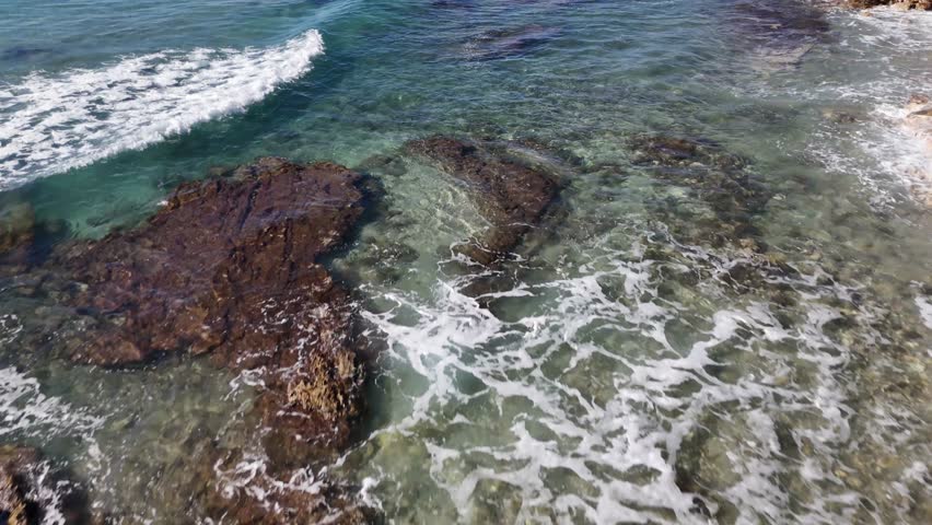 Top View of Coastal Waves Washing Over Rocks