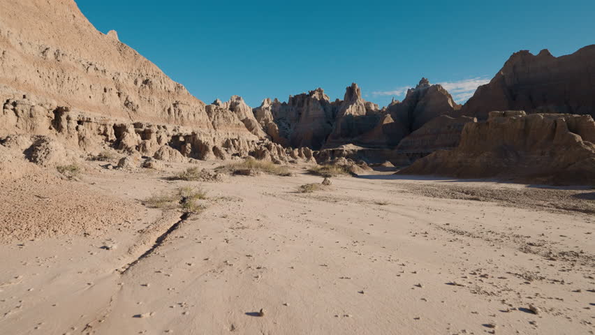 Badlands National Park rock formations reveal rich texture and color, with layered ridges, weathered clay and sweeping prairie creating a timeless rugged desert landscape under vast sky