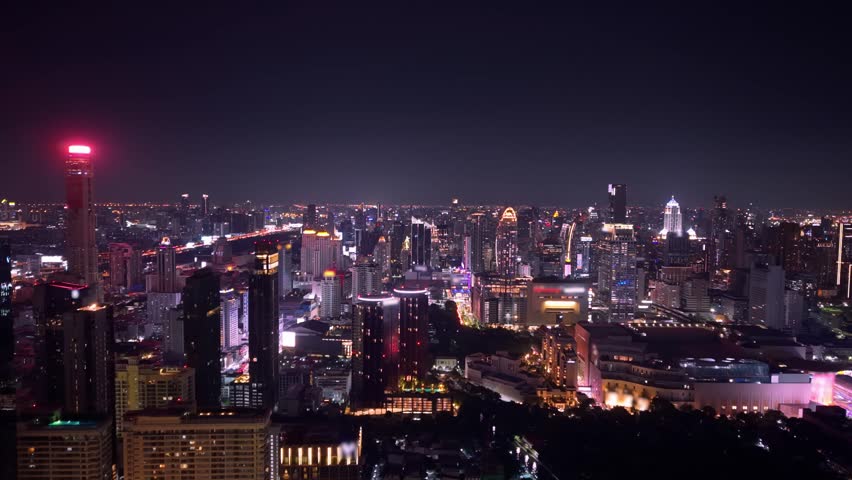 Night cityscape of Bangkok with modern skyscrapers and road traffic , aerial view Thailand.