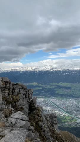 View on Innsbruck and the river Inn from mountains in April. Panorama view from the Nordkette top to Innsbruck and mountain range, Innsbruck, Tirol, Austria. Aerial view of the city of Innsbruck at the Hafelekar, Nordkette range. 