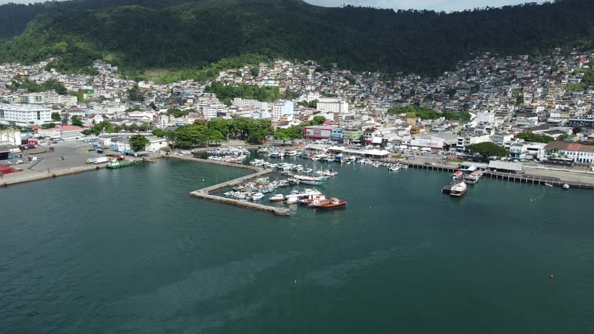 Drone view of Angra dos Reis fishing and touristic harbour with the town behind and surrounding tropical mountains. A scenic overview of a popular Brazilian seaside destination