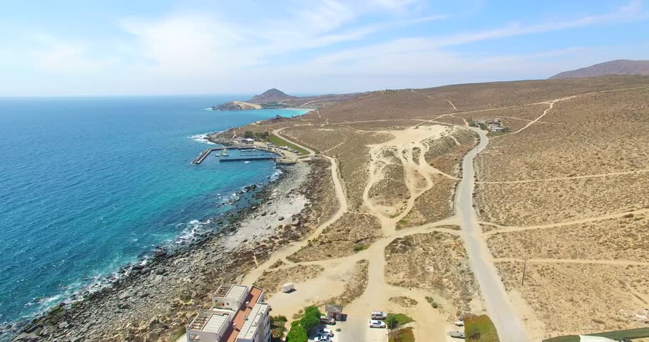Drone aerial view of a coastal road running alongside the ocean and rugged shoreline. Expansive natural landscape conveying freedom, travel, exploration and outdoor lifestyle.