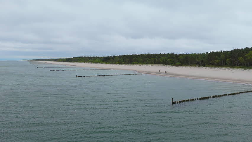 Views of a michigan beach with lake waves and wooden piers at dusk